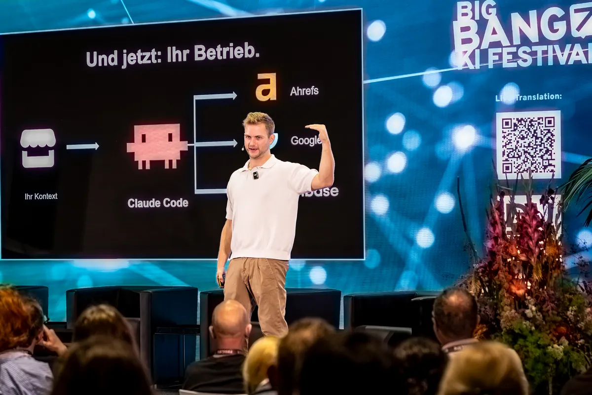Marco Heer vor der Folie „Und jetzt: Ihr Betrieb.“ auf dem BIG BANG KI Festival